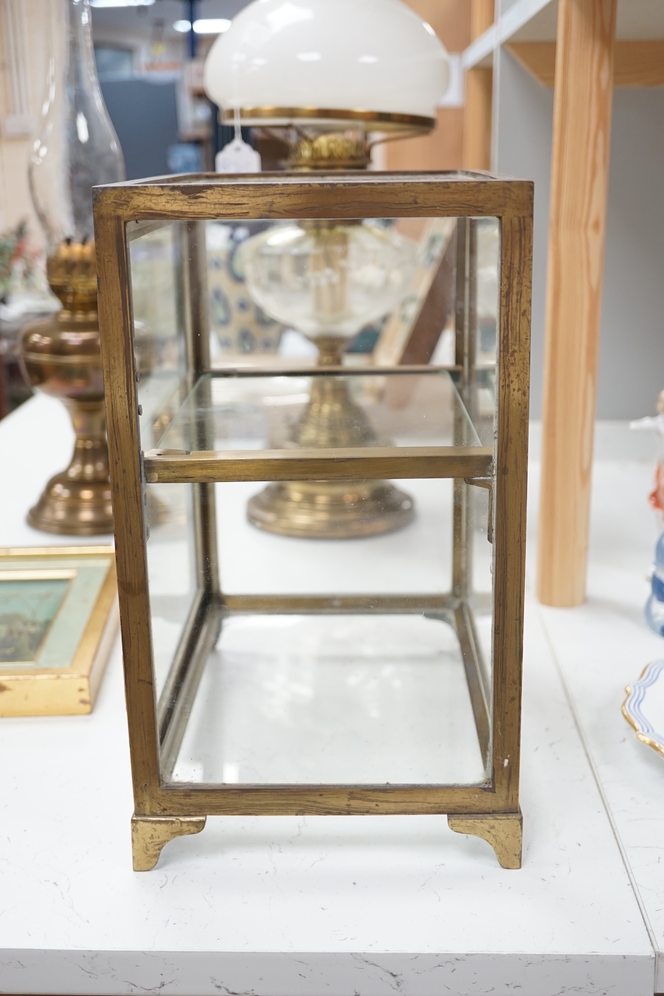 A small late 19th century brass display case, with glass shelf, bears plaque 'J Weiss & Son, 287 Oxford Street, London